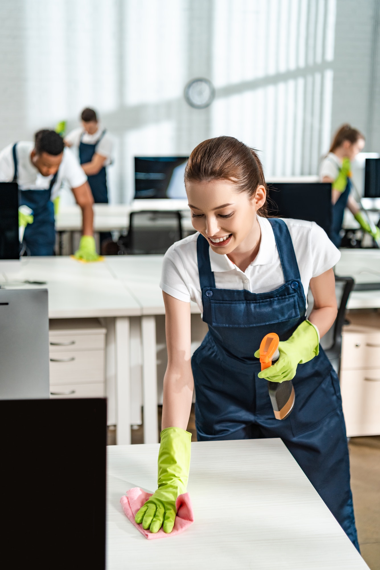 cheerful-cleaner-in-overalls-cleaning-office-desk-with-rag.jpg cheerful-cleaner-in-overalls-cleaning-office-desk-with-rag.jpg