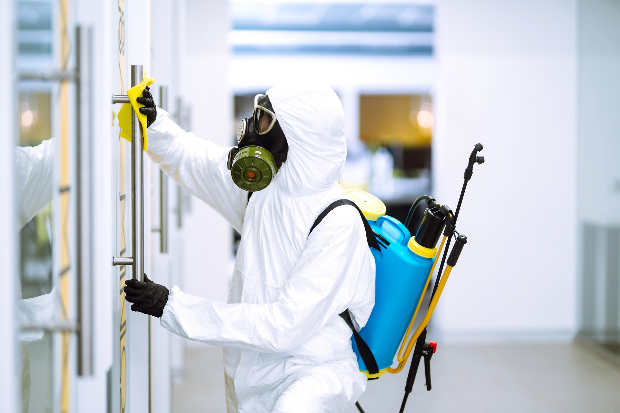Cleaning and disinfection of office to prevent COVID-19, Man in protective hazmat suit washes office Cleaning and disinfection of office to prevent COVID-19, Man in protective hazmat suit washes office